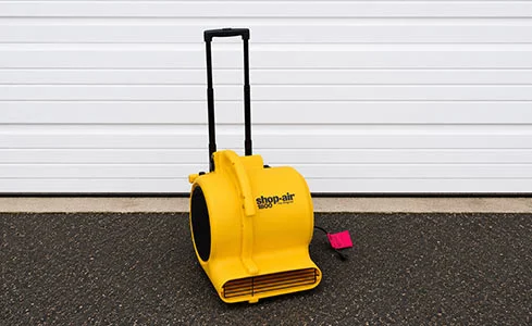 Heavy Duty Air Mover - Yellow air mover in front of garage