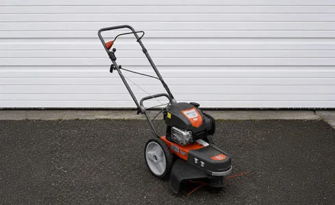 Mower Style String Trimmer - Husqvarna trimmer on asphalt driveway
