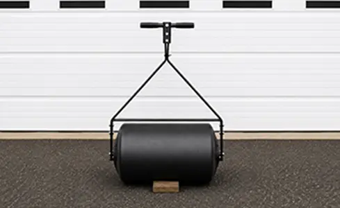 PolRoller - Black lawn roller against garage backdrop