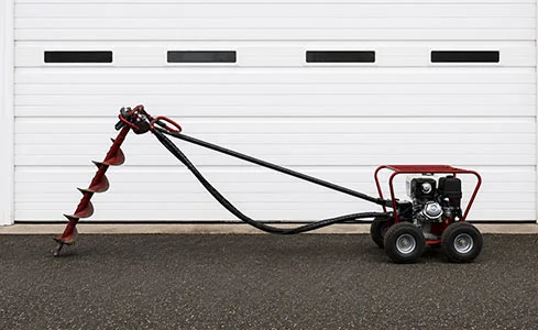 Post Hole Auger - Industrial auger on asphalt pavement